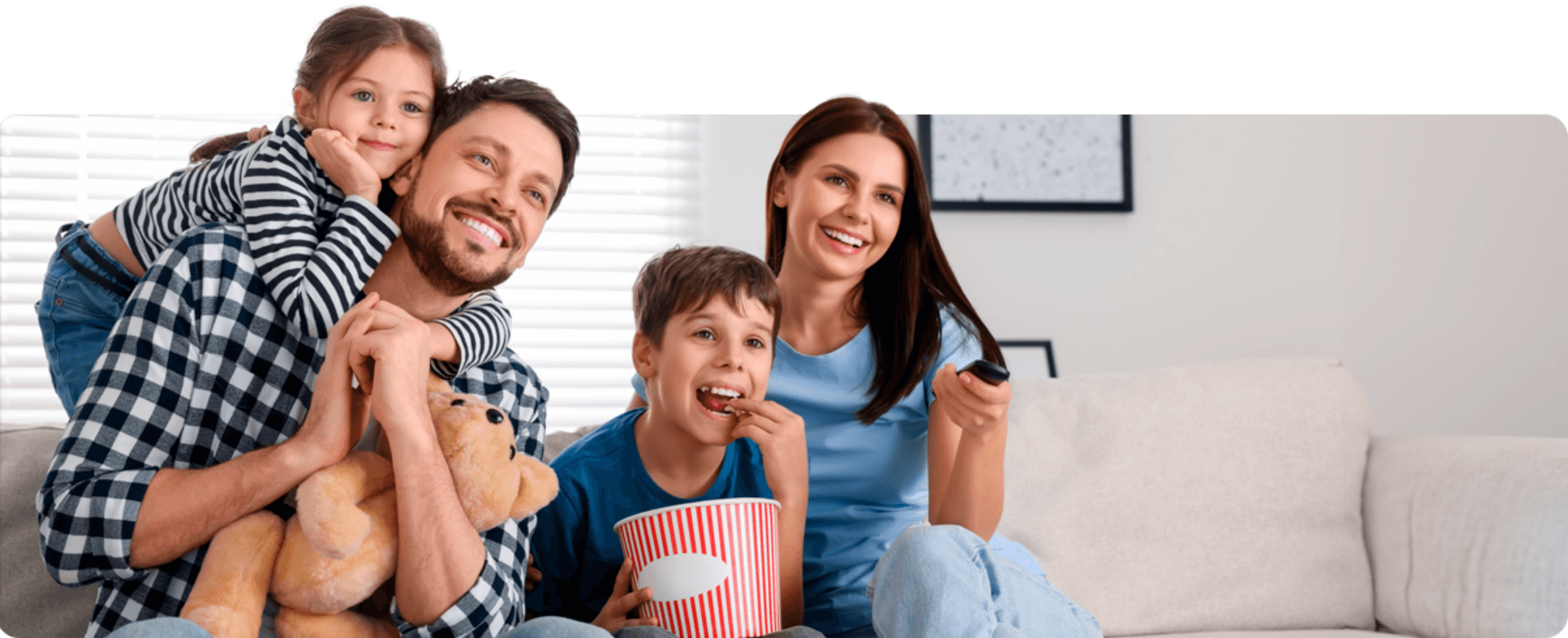 Familia reunida e sorridente enquanto assiste a um filme